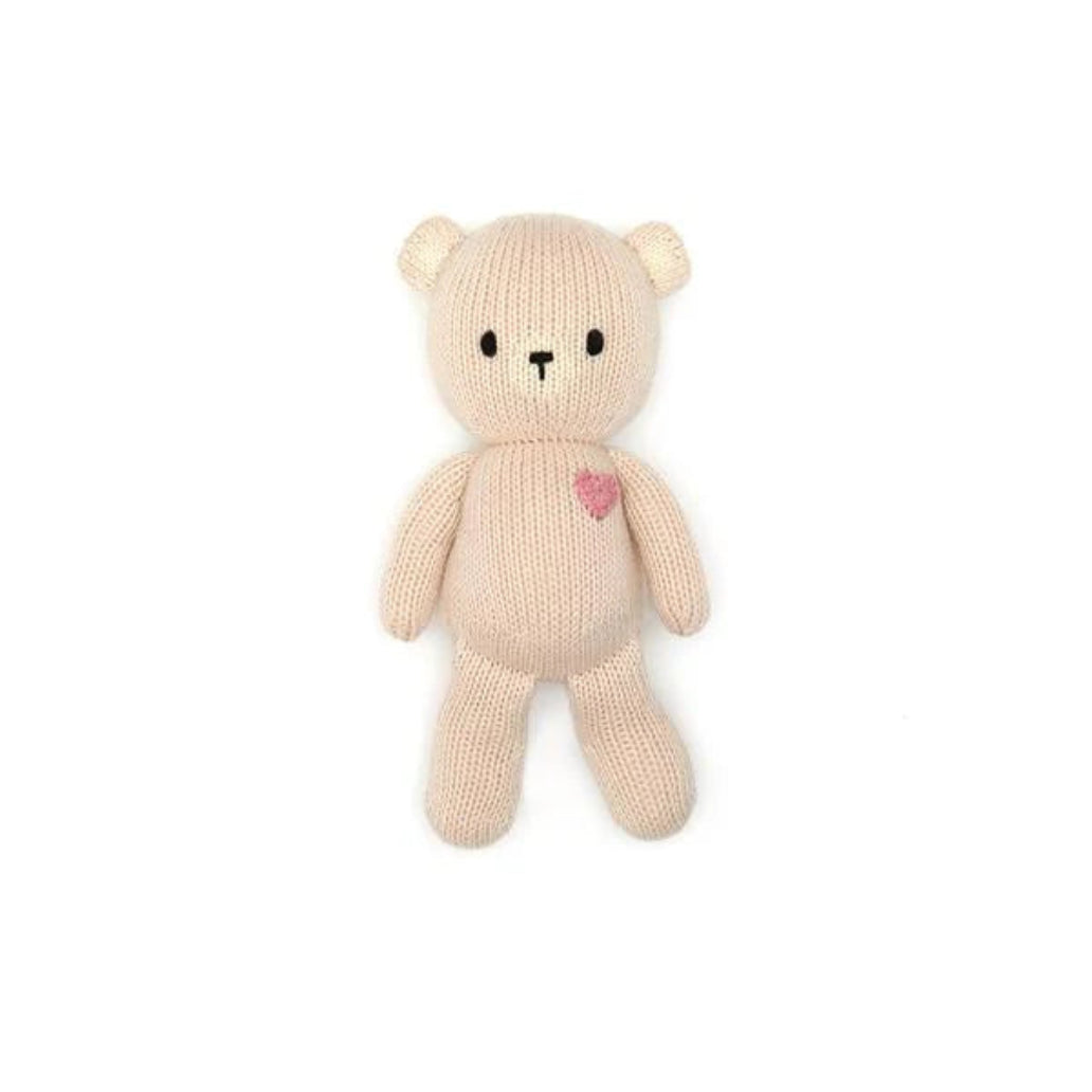 Knitted teddy bear with a heart on a white background
