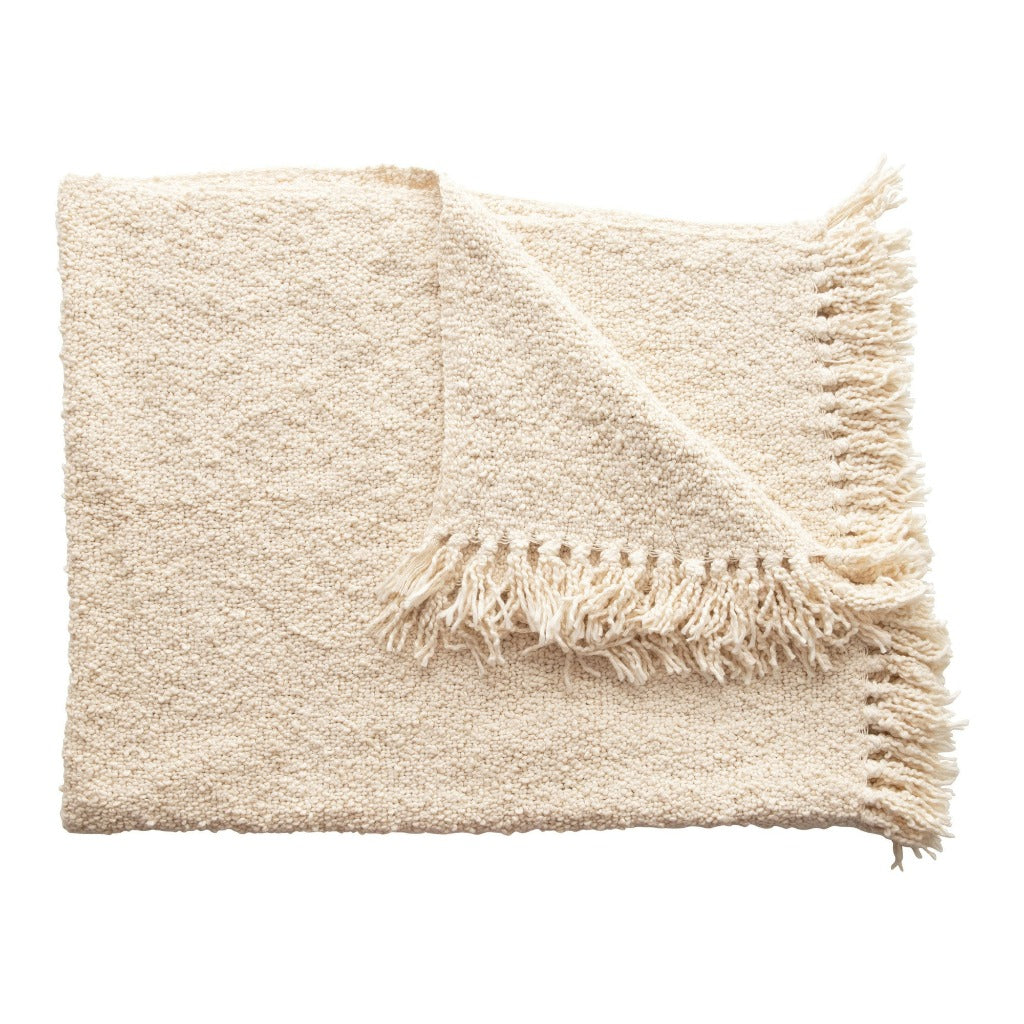 Cream colored cotton blend bouclé throw with fringe detailing draped over a black metal bench, with other similar throws in the background.

Boucle fringe throw blanket, boutique home décor from Ella Collective Raleigh.